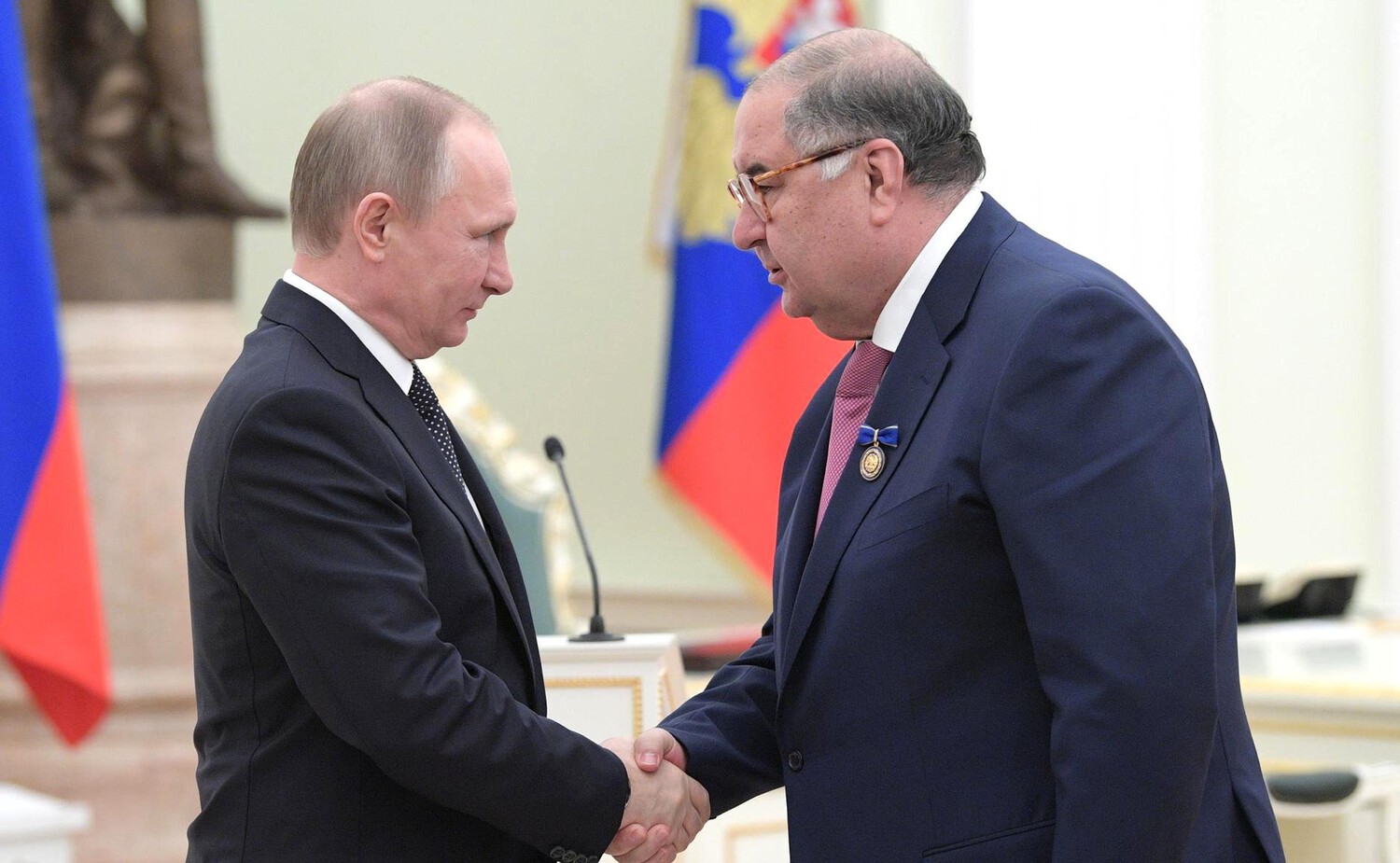 Oesmanov en Poetin schudden elkaar de hand.
