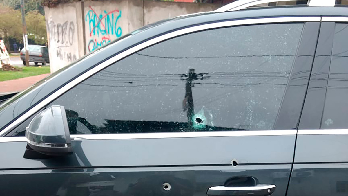 Auto is te zien met kogelgaten door de zijkant geschoten