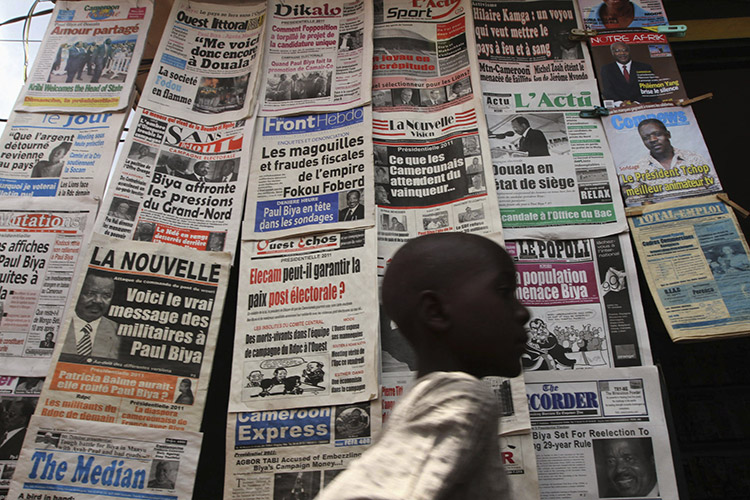 A boy walks past a newspaper kiosk in the Wada district of Cameroon's capital of Yaounde, in the run-up to the presidential elections of October 2011. Photo (c): Reuters / Akintunde Akinleye
